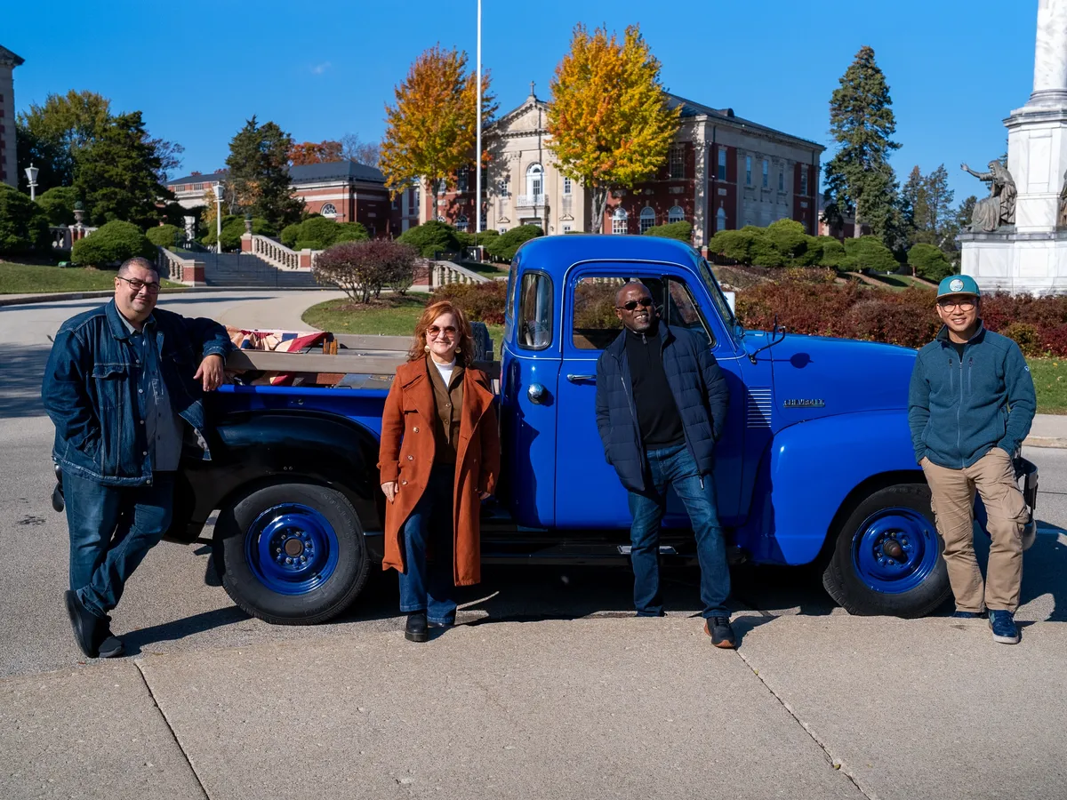 The four Accents co-founders together by a vintage blue truck